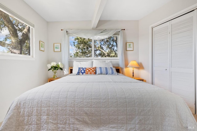 bedroom with a closet and beam ceiling