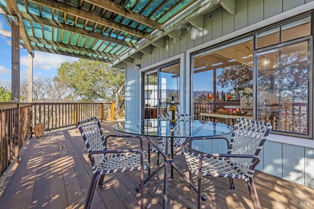 wooden terrace featuring outdoor dining space and a pergola