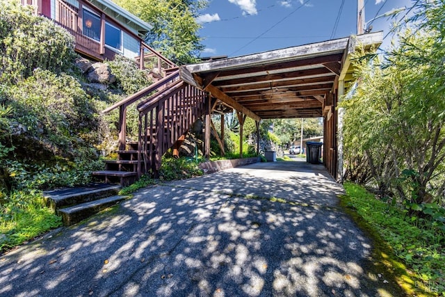 view of vehicle parking with aphalt driveway and stairway