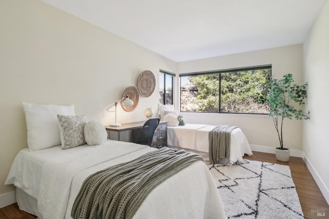 bedroom featuring wood finished floors and baseboards