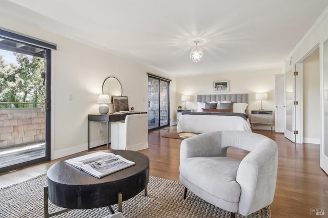 bedroom with access to exterior, an inviting chandelier, ornamental molding, wood finished floors, and baseboards