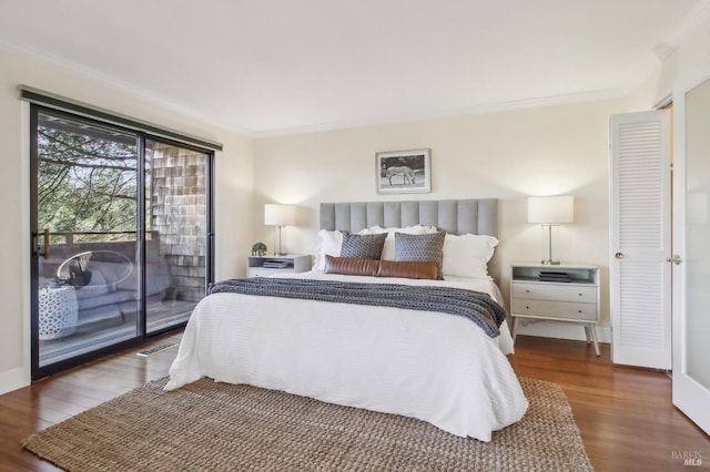 bedroom with crown molding, dark wood-type flooring, and access to exterior