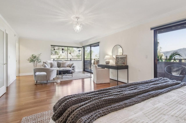 bedroom with access to exterior, ornamental molding, baseboards, and wood finished floors