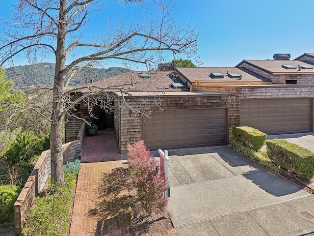 exterior space featuring a garage, concrete driveway, and a mountain view