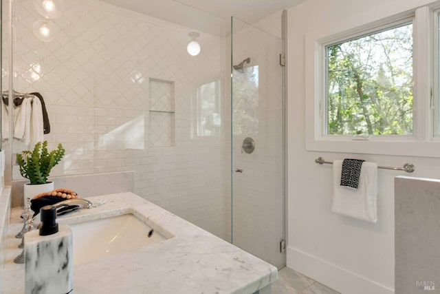 full bathroom featuring a stall shower, vanity, and baseboards