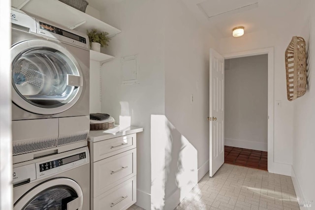 washroom with laundry area, brick floor, stacked washer and clothes dryer, and baseboards