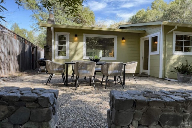 view of patio featuring outdoor dining space, fence, and grilling area