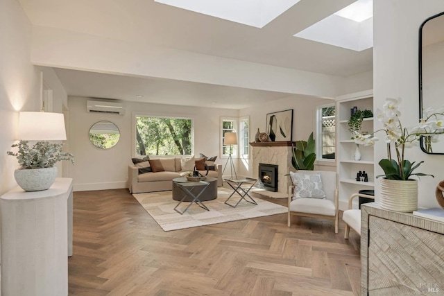 living room featuring a wall unit AC, a skylight, a lit fireplace, and baseboards