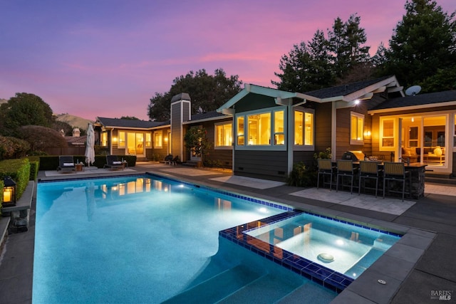 view of pool with a pool with connected hot tub and a patio