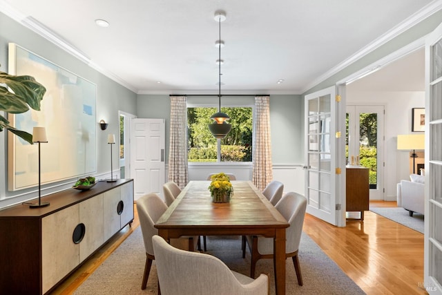 dining room with ornamental molding and light wood finished floors