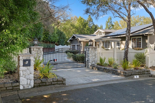 view of gate featuring a fenced front yard and roof mounted solar panels