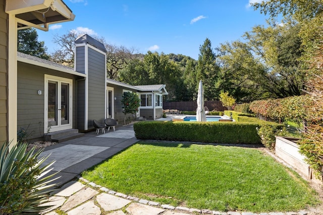 view of yard with a patio area, fence, and a fenced in pool