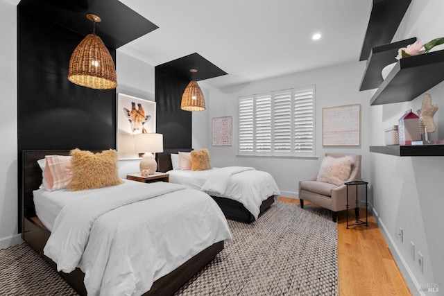 bedroom with recessed lighting, wood finished floors, and baseboards