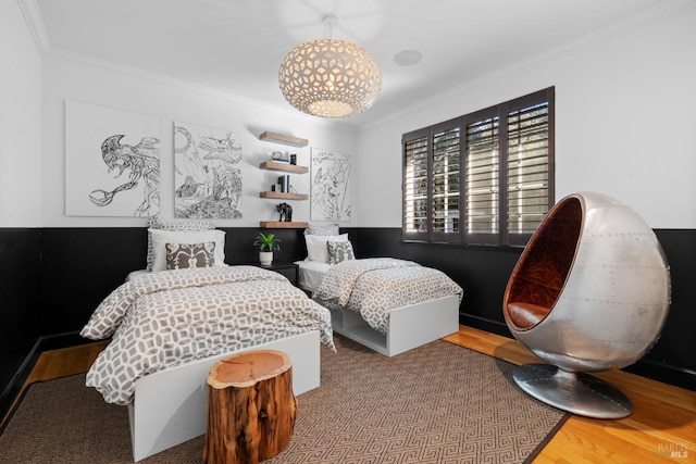 bedroom with wood finished floors and crown molding