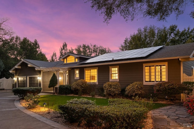 ranch-style house featuring a front yard and solar panels