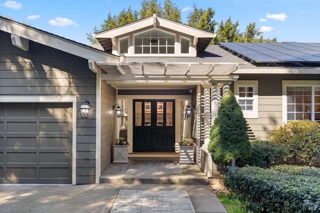 property entrance featuring an attached garage and roof mounted solar panels