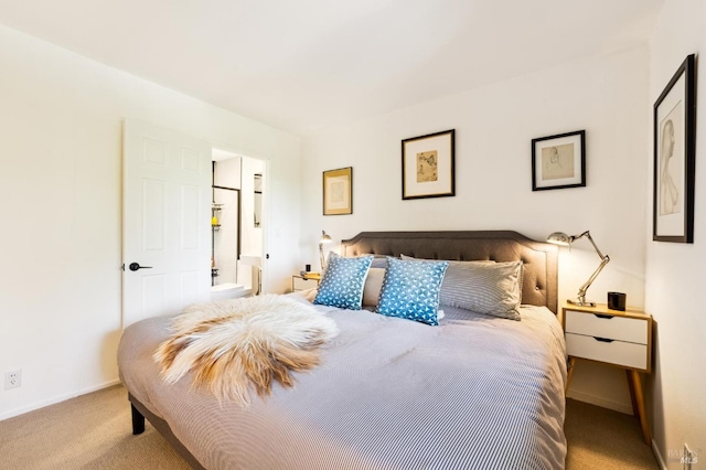 carpeted bedroom featuring ensuite bath and baseboards