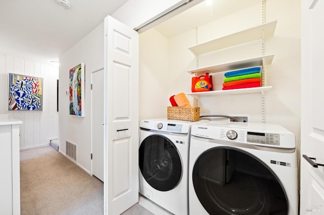 laundry room featuring visible vents, baseboards, laundry area, washing machine and dryer, and light colored carpet