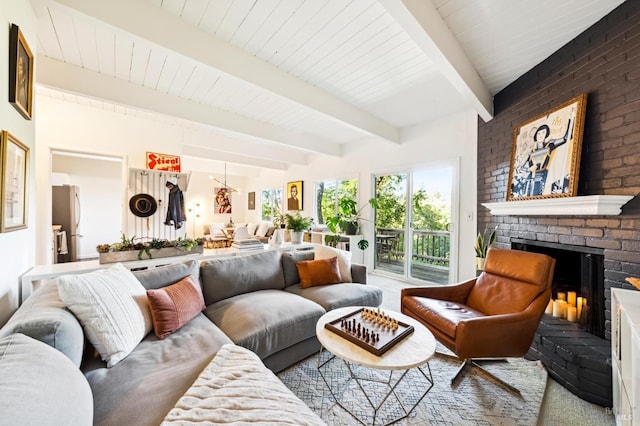 sunroom featuring beamed ceiling and a brick fireplace