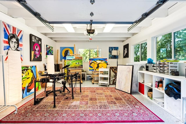 recreation room featuring beam ceiling and a garage