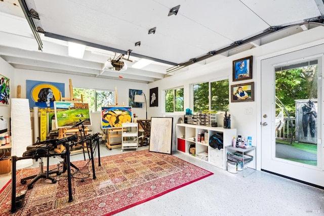 interior space with a garage, plenty of natural light, and speckled floor