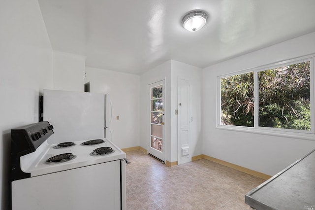 kitchen with light countertops, white appliances, white cabinetry, and baseboards