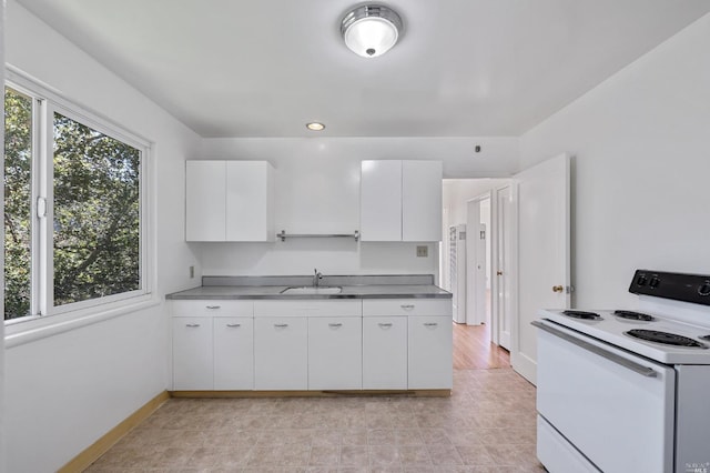 kitchen featuring a sink, baseboards, white cabinets, modern cabinets, and white electric range oven