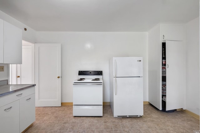 kitchen featuring light countertops, white appliances, white cabinetry, and baseboards