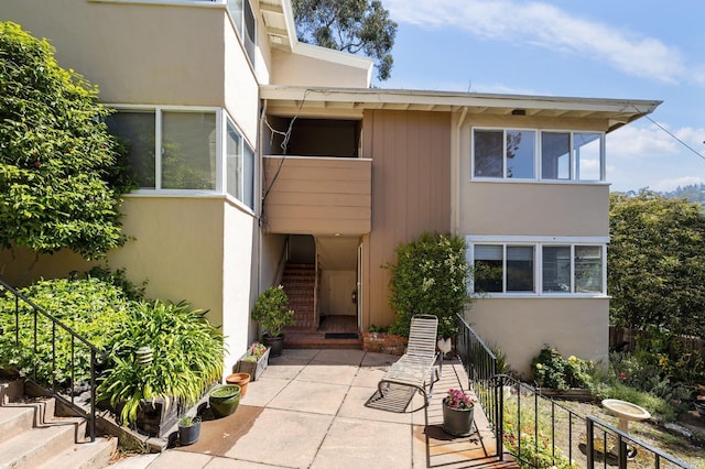 exterior space with a patio, stairway, and stucco siding