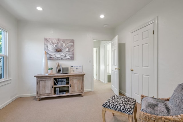 hallway with baseboards, recessed lighting, and light colored carpet