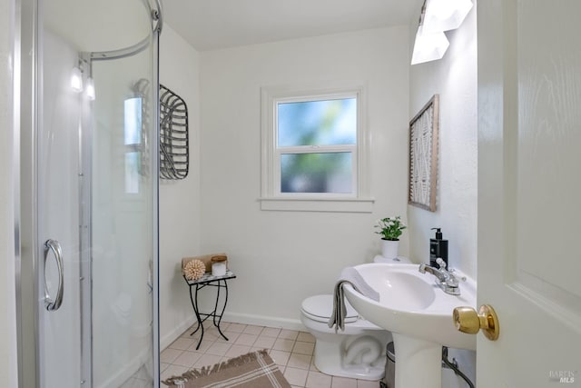 bathroom featuring a shower, baseboards, toilet, and tile patterned floors