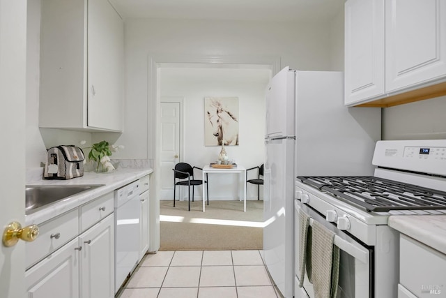 kitchen with light countertops, white appliances, white cabinets, and a sink