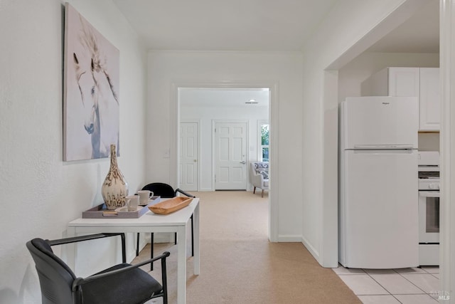 corridor with light carpet, light tile patterned floors, and baseboards