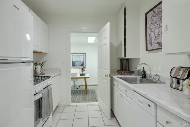 kitchen featuring white appliances, light tile patterned floors, white cabinetry, and a sink