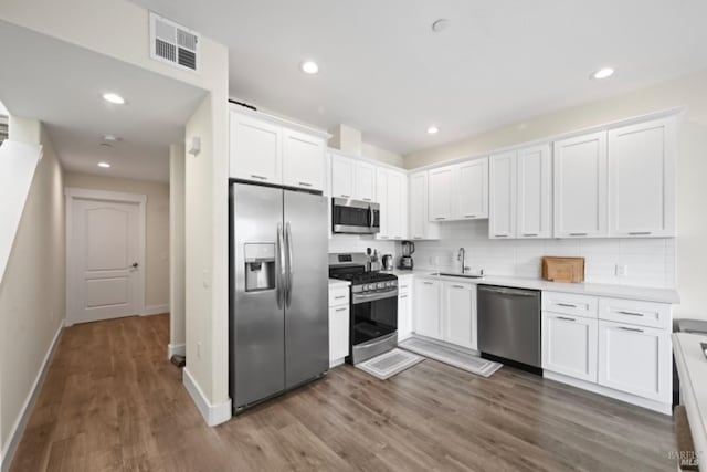 kitchen with stainless steel appliances, light countertops, and white cabinets