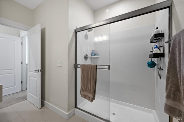 full bathroom featuring a shower stall, baseboards, and tile patterned floors