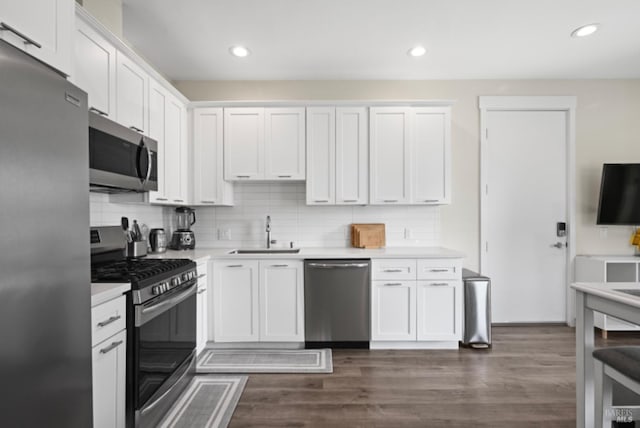 kitchen with white cabinetry, appliances with stainless steel finishes, light countertops, and a sink