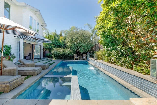 view of swimming pool featuring a patio area, a fenced backyard, and a pool with connected hot tub