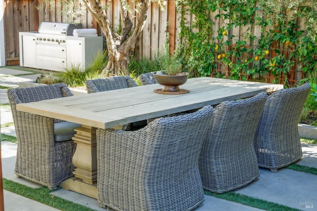 view of patio / terrace with a grill and fence