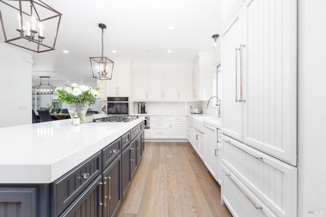 kitchen with white cabinets, stainless steel appliances, light countertops, and a center island