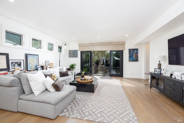 living area featuring baseboards, recessed lighting, and light wood-style floors