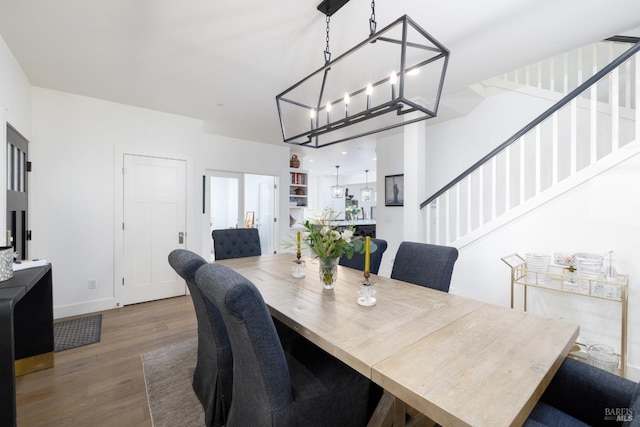 dining space with stairway, baseboards, and wood finished floors