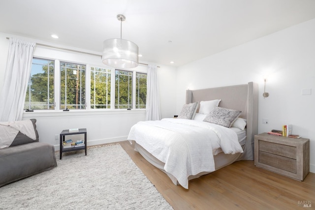 bedroom with recessed lighting and wood finished floors