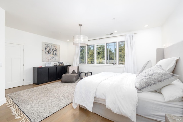 bedroom with wood finished floors, visible vents, and recessed lighting