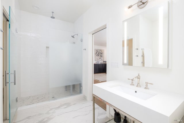 ensuite bathroom with a stall shower, marble finish floor, a sink, and ensuite bath