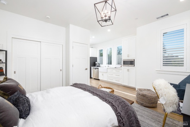 bedroom featuring light wood finished floors, visible vents, an inviting chandelier, a closet, and recessed lighting