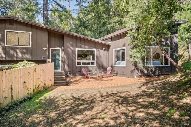 back of property featuring entry steps and fence