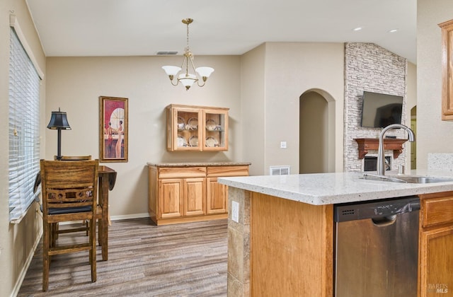 kitchen with arched walkways, visible vents, hanging light fixtures, a sink, and dishwasher