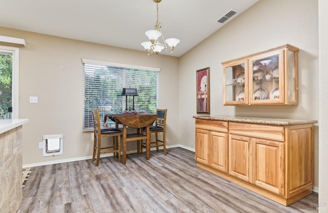 dining space featuring a notable chandelier, visible vents, a wealth of natural light, and wood finished floors