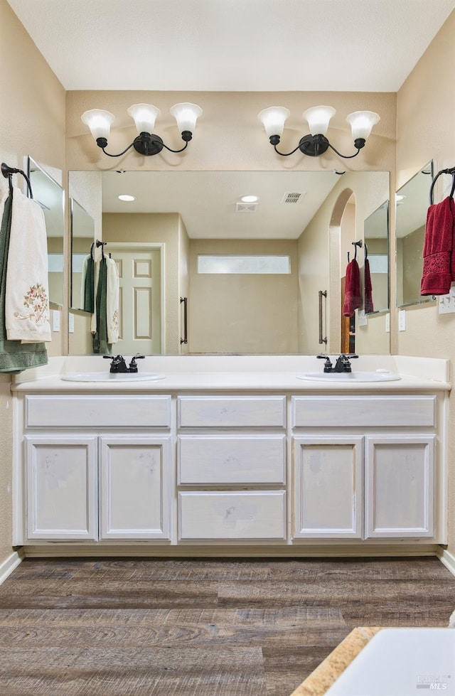 full bathroom featuring double vanity, a sink, visible vents, and baseboards